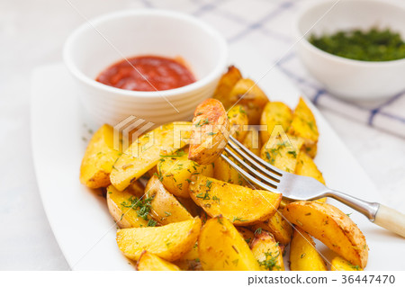 Baked potato slices with herbs in a white dish Baked potato slices with herbs in a white dish 36447470