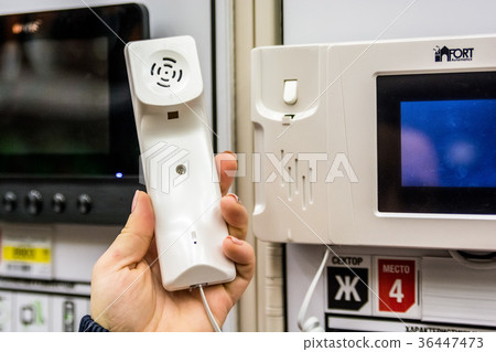 Hand holds handset of entry phone 36447473