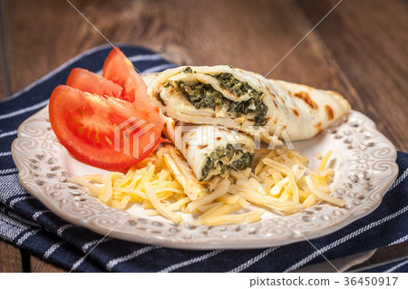 Crepes stuffed with cheese and spinach. 36450917