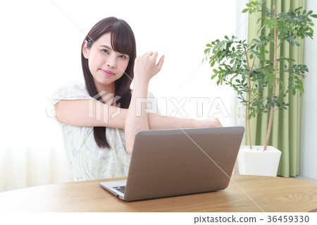 Young woman doing stretching in front of a laptop 36459330
