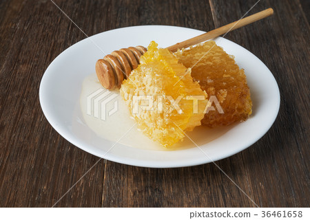 honeycomb and honey stick on a white plate 36461658