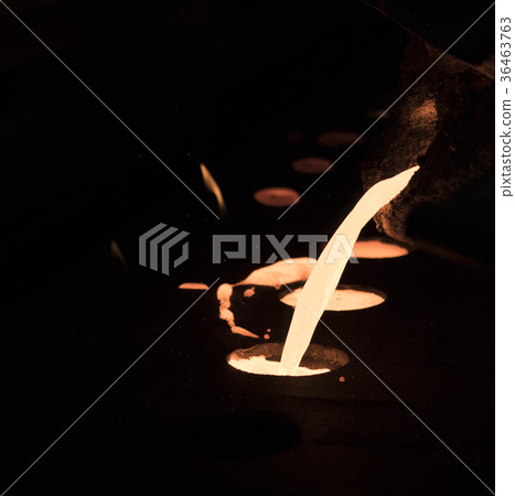 pouring molten metal into sand mold 36463763