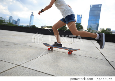 young woman skateboarder riding skateboard at city 36468066