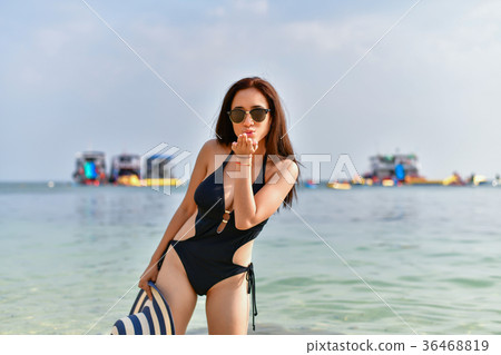 Beautiful woman wearing a swimsuit playing in the beach. 36468819