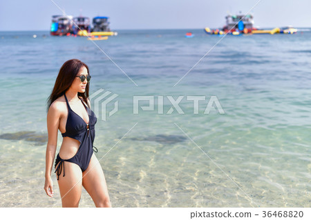 Beautiful woman wearing a swimsuit playing in the beach. 36468820