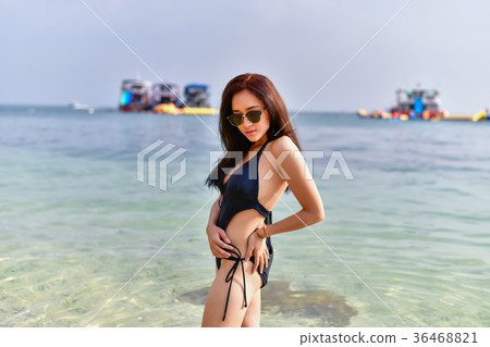 Beautiful woman wearing a swimsuit playing in the beach. 36468821