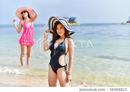 Beautiful woman wearing a swimsuit playing in the beach. Beautiful woman wearing a swimsuit playing in the beach. 36468823