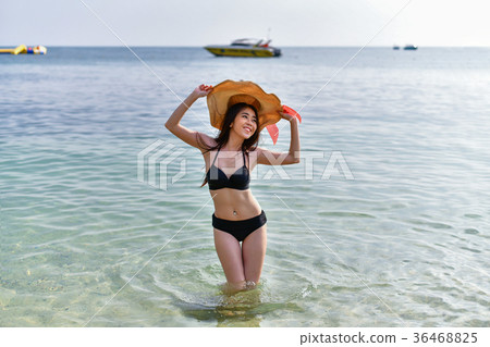 Beautiful woman wearing a swimsuit playing in the beach. 36468825