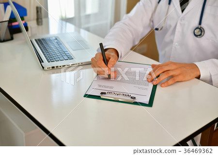 Smiling doctor posing in the office, he is wearing a stethoscope Smiling doctor posing in the office, he is wearing a stethoscope 36469362