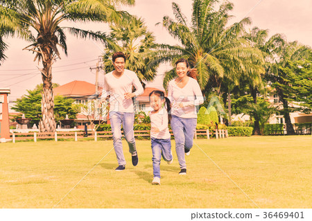 Parents and daughters go for a walk in the park. 36469401