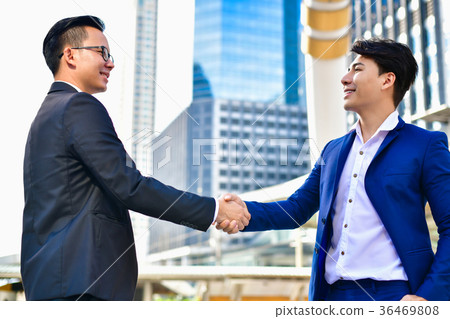 Young businessmen shake hands with fraudulent mode Young businessmen shake hands with fraudulent mode 36469808