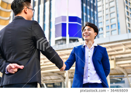 Young businessmen shake hands with fraudulent mode 36469809