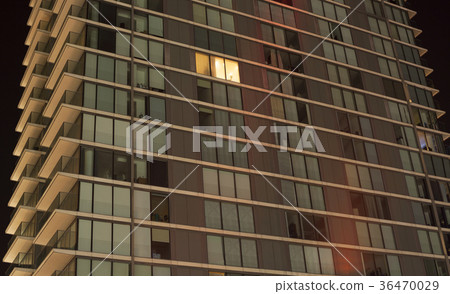 Single lit window in an apartment block at night Single lit window in an apartment block at night 36470029