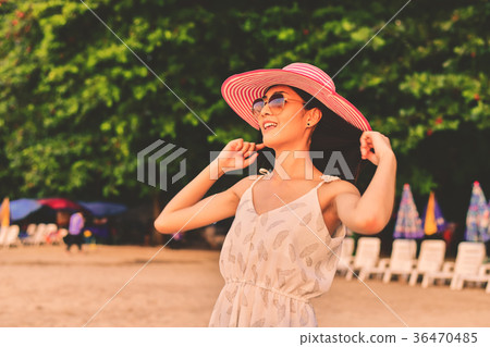 Beautiful girl is walking on the beach happily. 36470485