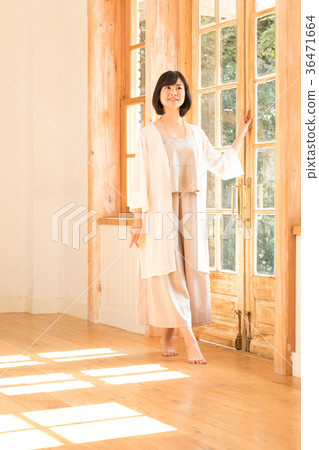 A young woman standing at the window A young woman standing at the window 36471664