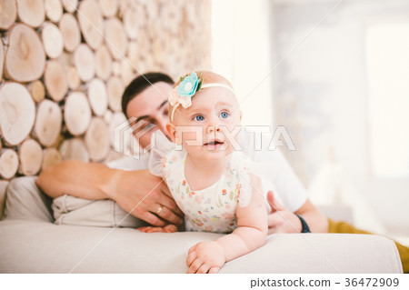 little baby girl blonde background of her parents. 36472909