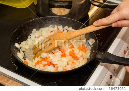 Stewed carrot and onion in frying pan 36473031