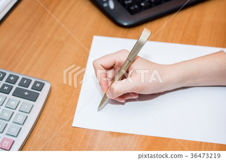 Close up hand with pen writes on paper on desk Close up hand with pen writes on paper on desk 36473219