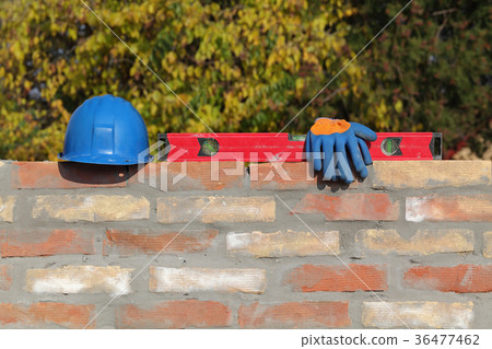 Construction worker equipment at brick wall 36477462