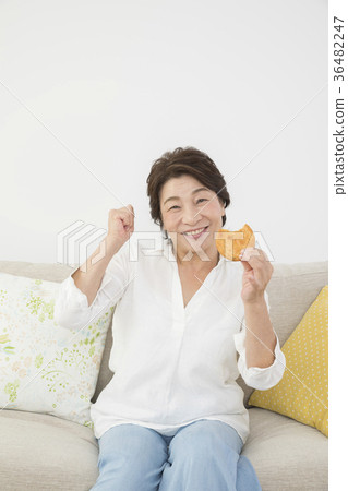 Senior woman eating a cracker so deliciously Dental health Senior woman eating a cracker so deliciously Dental health 36482247