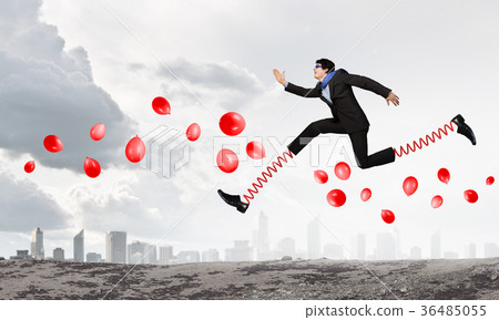 Businessman making wide jump Businessman making wide jump 36485055