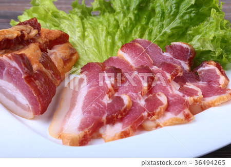 Fresh homemade smoked bacon with leaves 36494265