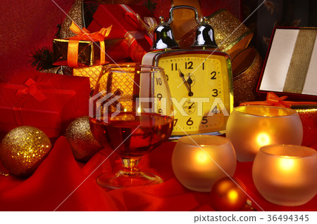 Christmas clock, glass with cognac and candles. 36494345