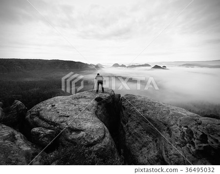 Artist photographer works with tripod on cliff Artist photographer works with tripod on cliff 36495032