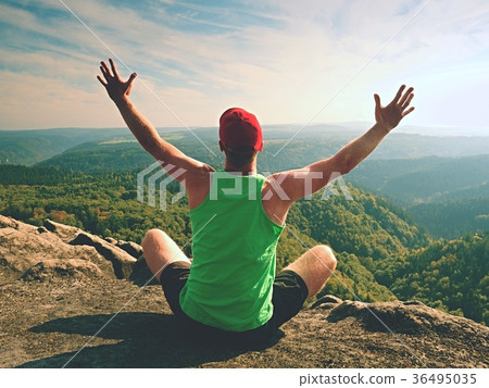 Man sit on top of the mountain in yoga pose 36495035