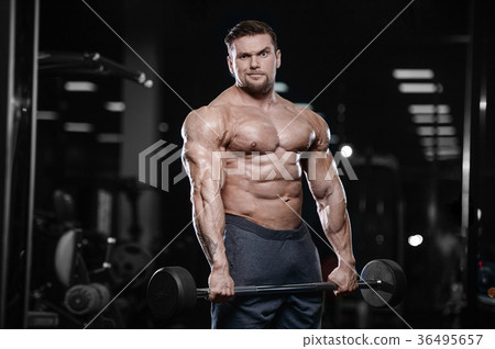 Brutal strong bodybuilder athletic men pumping up muscles with d 36495657