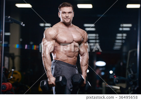 Brutal strong bodybuilder athletic men pumping up muscles with d 36495658