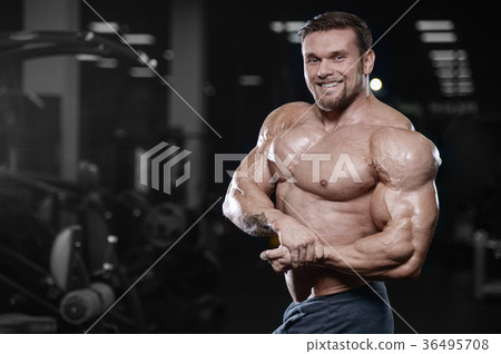 Brutal strong bodybuilder athletic men pumping up muscles with d 36495708