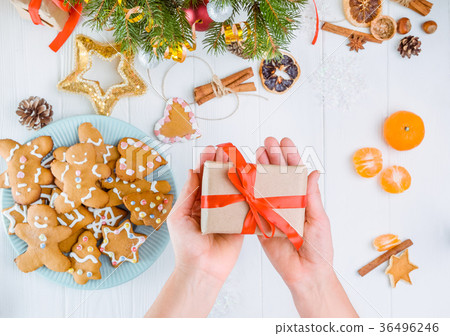 female hands holding gift with red satin ribbon 36496246