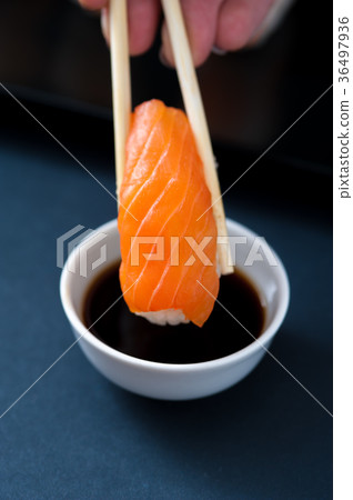 Chopstick with Salmon sashimi and soy sauce Chopstick with Salmon sashimi and soy sauce 36497936