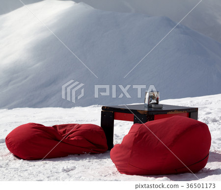 Bean bag chairs and table in outdoor cafe at ski resort 36501173