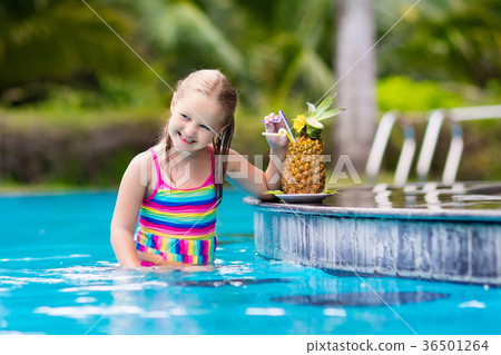 Child drinking juice in swimming pool bar 36501264