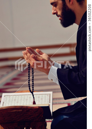 Religious muslim man praying inside the mosque 36502208