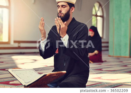 Muslim man and woman praying for Allah in the 36502209