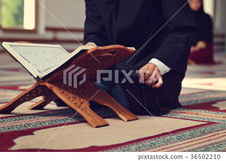 An open Holy quran with wood stand with praying 36502210