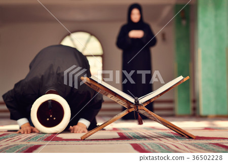 An open Holy quran with wood stand with praying 36502228