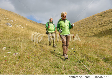 Senior tourist couple hiking at the beautiful Senior tourist couple hiking at the beautiful 36502332