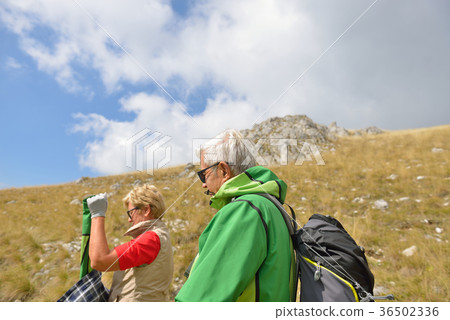 Senior tourist couple hiking at the beautiful Senior tourist couple hiking at the beautiful 36502336