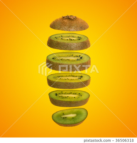 Creative concept with flying kiwi. Sliced kiwi isolated on yellow background 36506318
