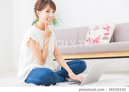 看便攜式計算機的婦女在屋子裡 看便攜式計算機的婦女在屋子裡 36508192