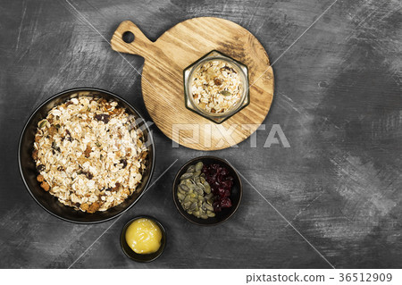 Granola with honey, nuts, fruit on dark background Granola with honey, nuts, fruit on dark background 36512909