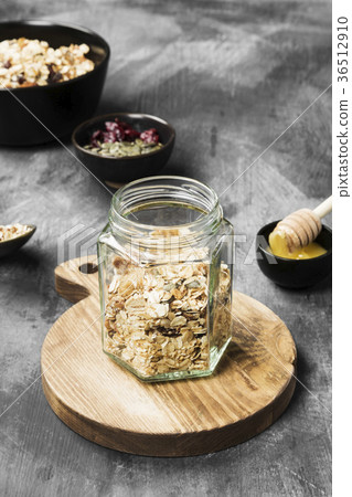 Granola with honey, nuts, fruit on dark background Granola with honey, nuts, fruit on dark background 36512910