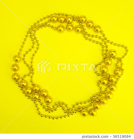 Golden beads on a yellow background Golden beads on a yellow background 36519084