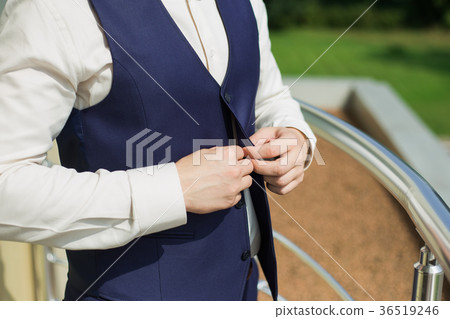 man buttoning vest of blue suit man buttoning vest of blue suit 36519246