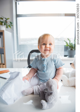Beaming little child sitting on table 36530650