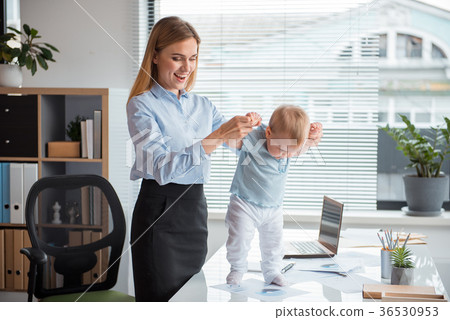 Outgoing female playing with kid at workplace Outgoing female playing with kid at workplace 36530953